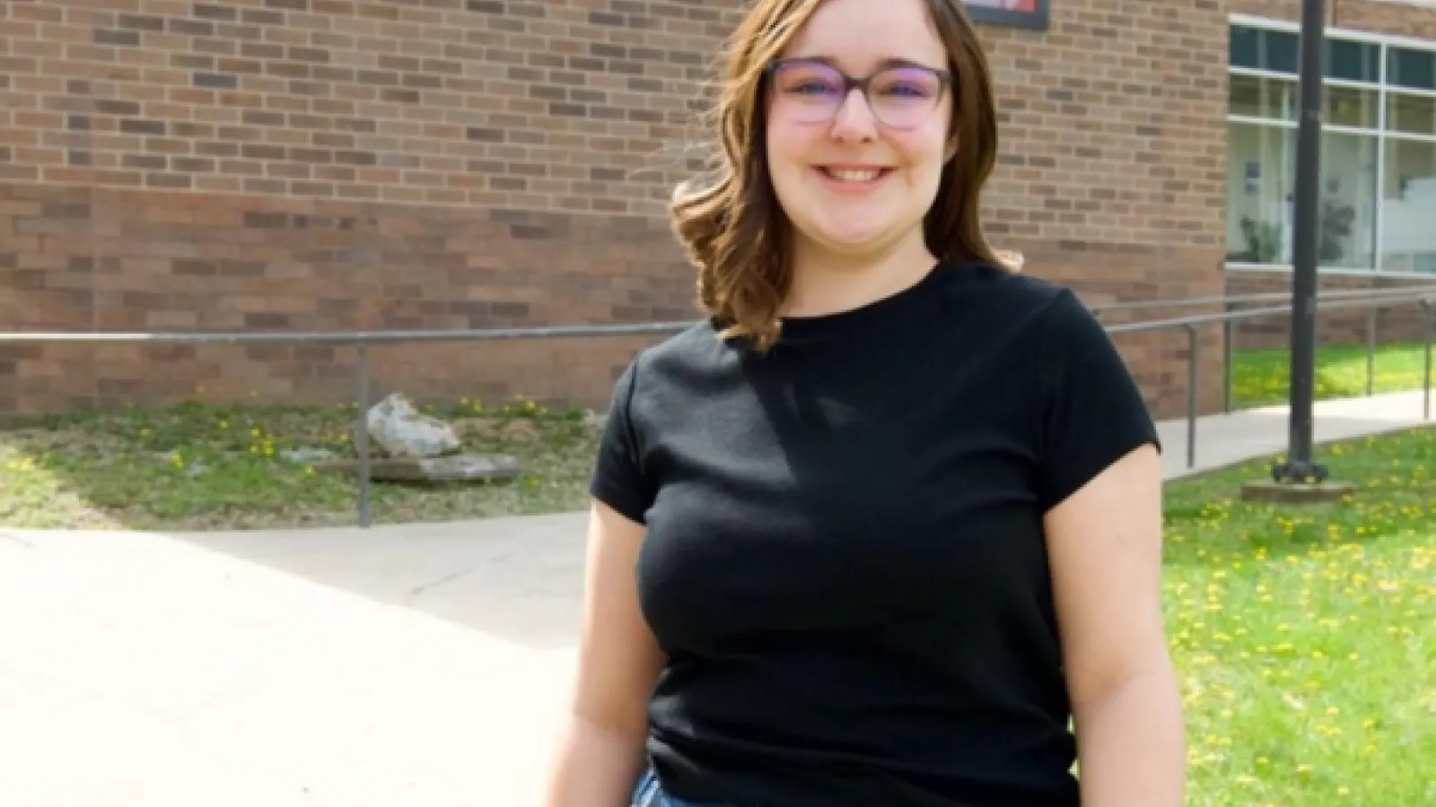 Sophia Wood standing in front of a brick building. 