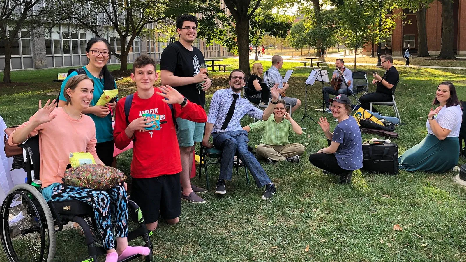 Group of people smiling and waving at the camera