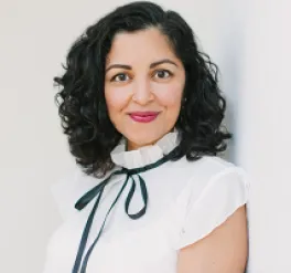 Alumna, author and professor Aimee Nezhukumatathil poses, smiling, in front of a white background